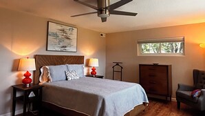 A bedroom with a bed, two bedside tables with lamps, a ceiling fan, a window, and a chair. - Cozy 1-bedroom apartment in lovely Weaverville with AC (Weaverville)