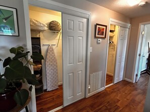 A hallway with wooden flooring, white doors, a plant, a towel rack, and a vent. - Cozy 1-bedroom apartment in lovely Weaverville with AC (Weaverville)
