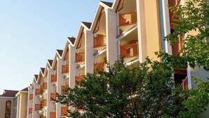 Un hotel de varios pisos con balcones y un cielo despejado.