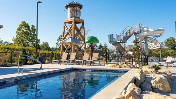 Una piscina con un tobogán de agua y una torre de vigilancia.