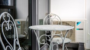 Une table et des chaises en métal, avec un radiateur blanc en arrière-plan.