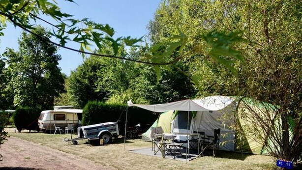 En campingplads med et telt, en autocamper og en campingvogn.