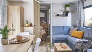 Ein modernes Wohnzimmer mit Sofa, Couchtisch und Essbereich.
