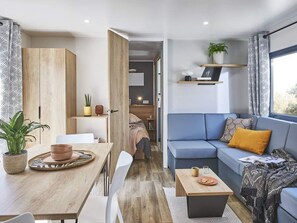 Ein modernes Wohnzimmer mit Sofa, Couchtisch und Essbereich.