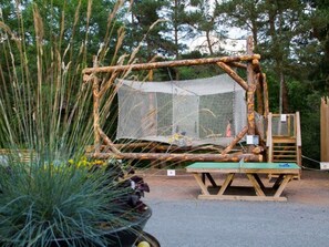 A wooden structure with a mesh enclosure, surrounded by trees and a potted plant. - Family mobile home, pets welcome - 6 guests (Saint-Paulien)