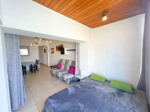Ein modernes Schlafzimmer mit einem großen Bett, einer Couch und einem Essbereich.