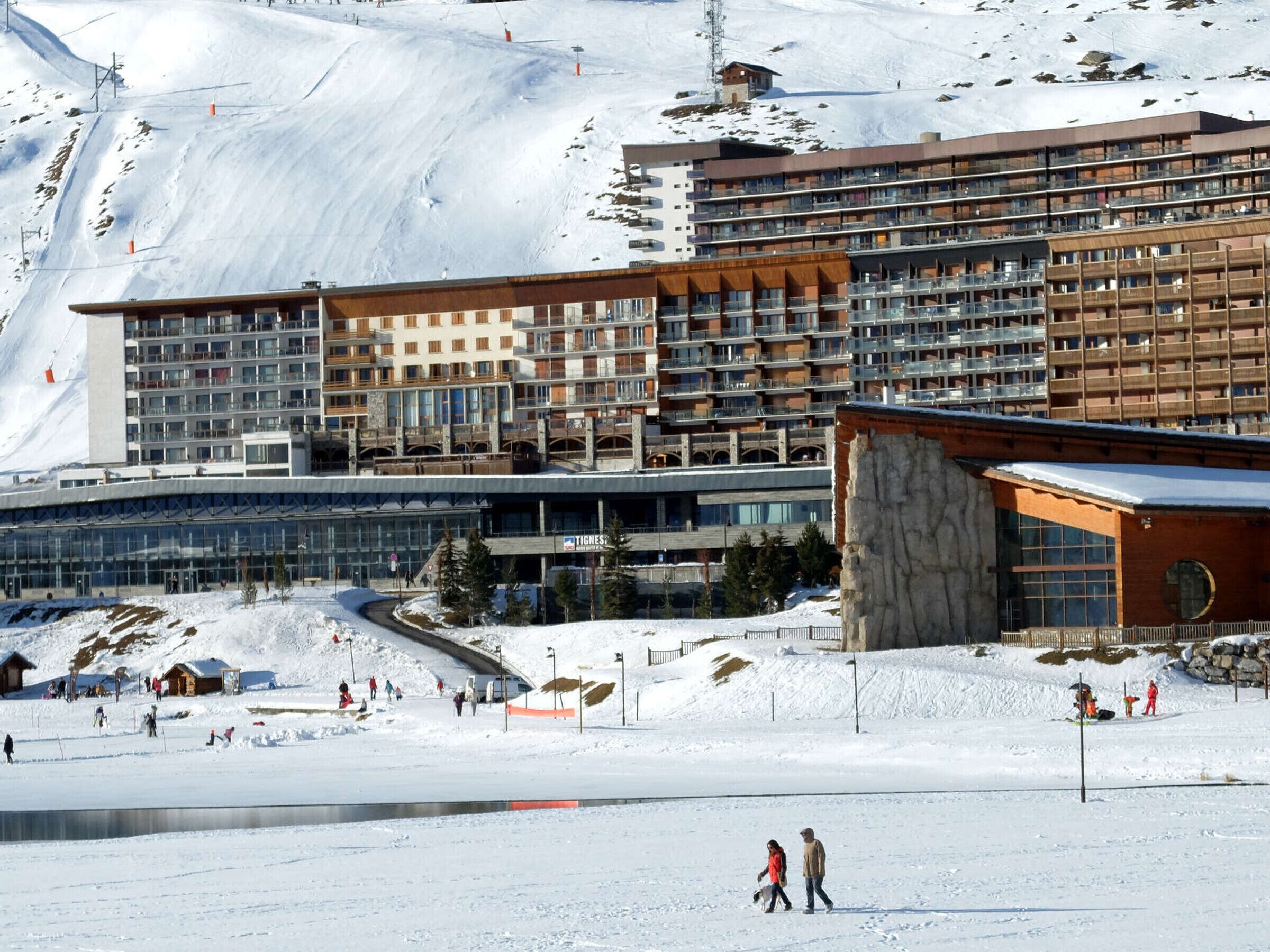 A hotel with multiple floors, large windows, and a ski resort in the background.