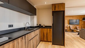 Eine moderne Küche mit einer Wand in Holzoptik, einem eingebauten Ofen und einem großen Kühlschrank.