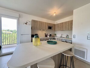 Eine moderne Küche mit einer Kochinsel, einer Mikrowelle und einem Kühlschrank.