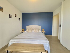 Ein Schlafzimmer mit einem Bett, zwei Nachttischen und einer hölzernen Bank.