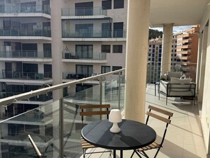 A balcony with a round table, chairs, and a lamp. - Mediterranean comfort apartment - 4 guests (Villajoyosa)