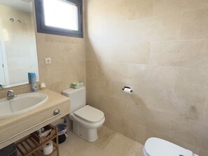 Ein Badezimmer mit Waschbecken, Toilette und einem Fenster.