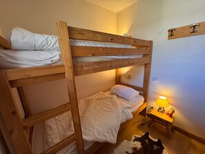 A bunk bed room with a bedside table and lamp. - Apartment mountain view, pets welcome - 6 guests (Vars)