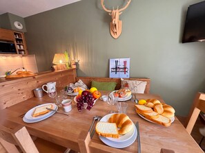 A wooden dining table with plates of food, glasses, and cutlery. - Apartment mountain view, pets welcome - 6 guests (Vars)