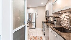 A compact kitchen with stainless steel appliances, a microwave, and a coffee maker. - Walk to Siesta Key Beach and Village - Beautifully Renovated 2BR Condo (Siesta Key)