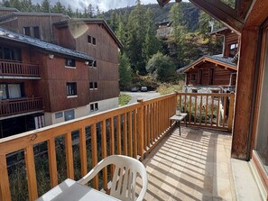 Ein Holzbalkon mit Blick auf einen Berg und ein Gebäude.