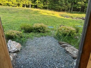 A gravel pathway leading to a grassy area with small ponds and rocks.