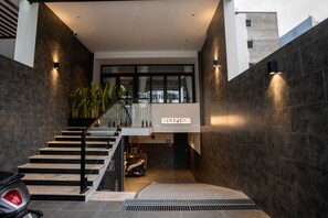 A reception area with a staircase leading to upper floors, a reception desk, and a parked scooter. - Bin Bin Hotel 19 - Near Saigon Riverside (Ho Chi Minh City)