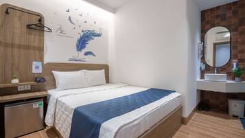 Ein Hotelzimmer mit einem Bett, einem Nachttisch, einem Spiegel und einer Wand mit einem Wandbild von Vögeln und Natur.