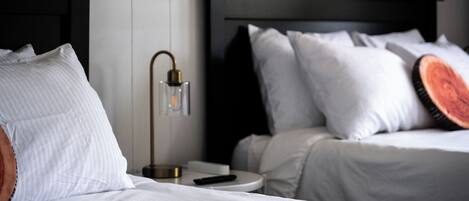 Een hotelkamer met twee bedden, een nachtkastje, een lamp en een afstandsbediening.
