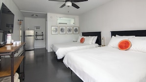 A hotel room with two beds, a ceiling fan, a refrigerator, a desk with a chair, and a mirror. - Lumber Jill Lodge Rooms (Balsam Lake)
