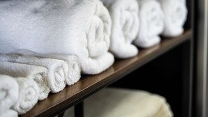 A shelf with neatly folded white towels. - Lumber Jill Lodge Rooms (Balsam Lake)