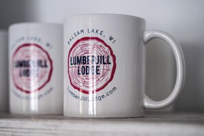 To hvide krus med sort og rød tekst, hvoraf det ene siger 'Lumber Jill Lodge' og det andet 'Balsam Lake, WI'.