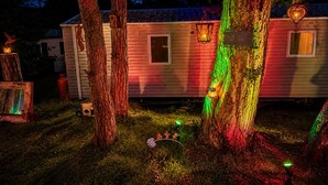 Uma casa móvel com varanda, uma janela pequena e uma placa com a inscrição 'Emily's Nursery'.