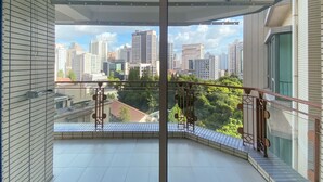 A balcony with a city view, a tiled floor, and a metal railing. - Tyms 3BR 2BA Residence Xujiahui (Shanghai)