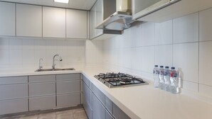 A modern kitchen with a gas stove, stainless steel cabinets, and a sink. - Tyms 3BR 2BA Residence Xujiahui (Shanghai)