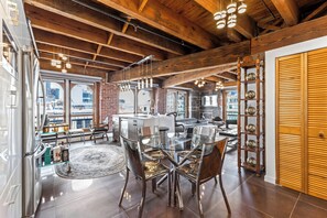 A modern kitchen with a glass dining table, stainless steel appliances, and a wooden ceiling. - Spacious & Charming 3BR - Heart of Old Montreal (Montréal)