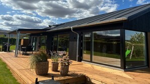 A modern house with a deck, large windows, and a clear sky. - "Illona" - 200m from the sea by Interhome (Hejls)