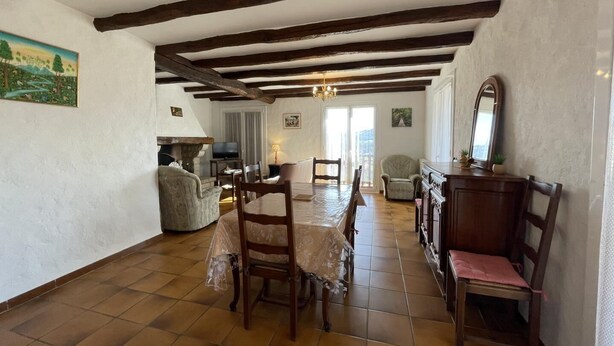 A dining area with a wooden table and chairs, a fireplace, and a television. - MENDIKO-LOREA - SAINT-PEE-SUR-NIVELLE (SAINT-PEE-SUR-NIVELLE)