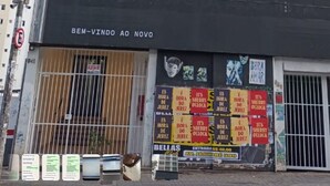 A multi-story building with balconies and a black storefront with signage. - Quarto Quádruplo Augusta Paulista e Frei (São Paulo)