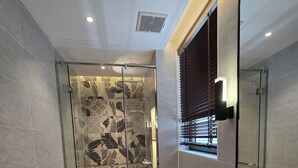A modern bathroom with a glass-enclosed shower, a toilet, and a large mirror. - Ngoc Khanh Villa Bai Khem Phu Quoc (Phu Quoc)