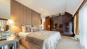 A bedroom with a large bed, bedside lamps, a dresser, and a wardrobe. - Spacious Penthouse Near Hyde Park London (London)