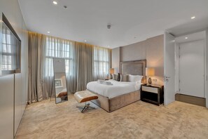 Ein modernes Hotelzimmer mit einem großen Bett, einem Nachttisch, einem Spiegel und einem Fenster mit Vorhängen.