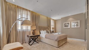 A bedroom with a bed, a desk, a chair, and a large window with curtains. - Beautiful Apartment With Lift in Baker St (London)