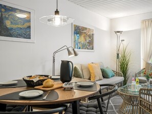 A dining area with a round table, chairs, a coffee machine, and a basket of bread. - "Ineke" - 200m from the sea by Interhome (Lemvig)
