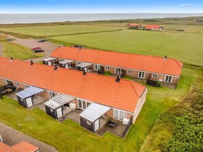 A large, modern building with a red-tiled roof, multiple rooms, and a spacious outdoor area. - "Ineke" - 200m from the sea by Interhome (Lemvig)