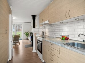 A modern kitchen with wooden cabinets, a built-in oven, and a stainless steel sink. - "Ineke" - 200m from the sea by Interhome (Lemvig)
