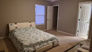 A bedroom with a bed, a ceiling fan, a window, and a door. - Minutes to Beach - Cozy Townhouse in PCB (Panama City Beach)