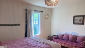 A bedroom with a bed, a sofa, a window, a chandelier, and a picture on the wall. - Perfect 3 bedroom house with AC in awesome Petaluma neighborhood near downtown (Petaluma)