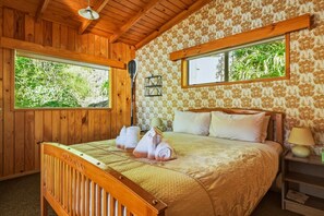 A wooden room with a bed, two windows, and a lamp. - Rotoiti Boathouse - Waterfront, Jetty, Kayaks (Rotoiti Forest)