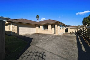 Ein Wohnhaus mit Garage, Auffahrt und kleinem Vorgarten.