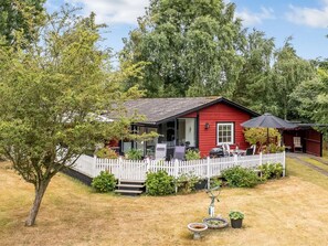 A red house with a white picket fence, a barbecue area, and a small garden with a birdbath. - "Aiske" - 700m from the sea by Interhome (Dannemare)