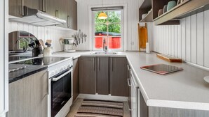 Eine moderne Küche mit Backofen, Spüle und einem Fenster mit Blick ins Freie.