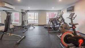 A gym with various exercise equipment, large windows, and a flat-screen TV on the wall. - Spacious 3 1/2-bedroom condo in Montreal (Montréal)