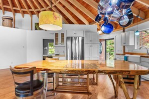 A modern kitchen with a large island, stainless steel appliances, and a rustic ceiling. - Cranberry Cottage - NEW! Home in Trenton (Trenton)