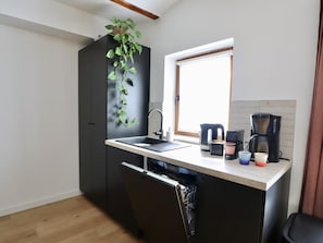 A compact kitchen with a built-in dishwasher, a sink, and a window above the counter. - Intimate village house with a rural location. (Palenge)